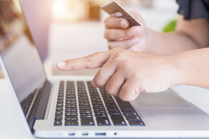 authorize hands entering credit card number on laptop