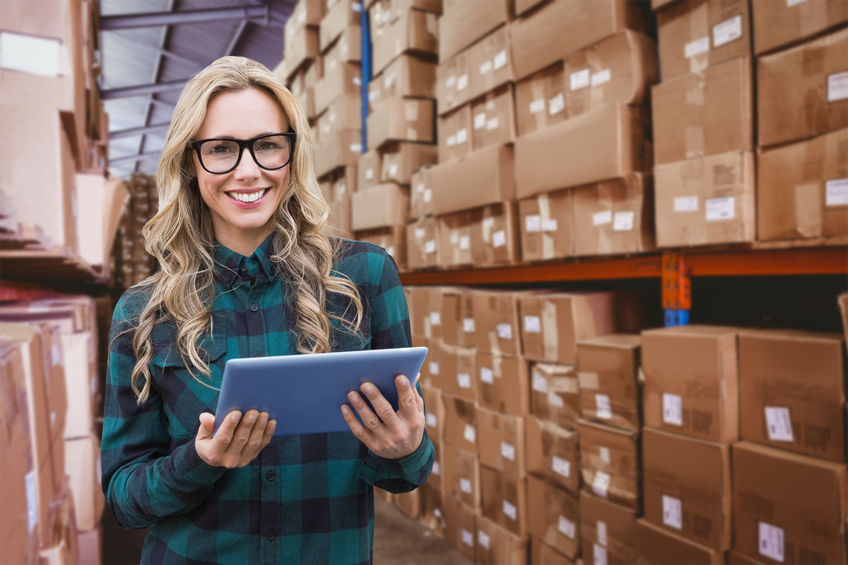 42230564 – pretty blonde with tablet against forklift in large warehouse woman smiling in a warehouse